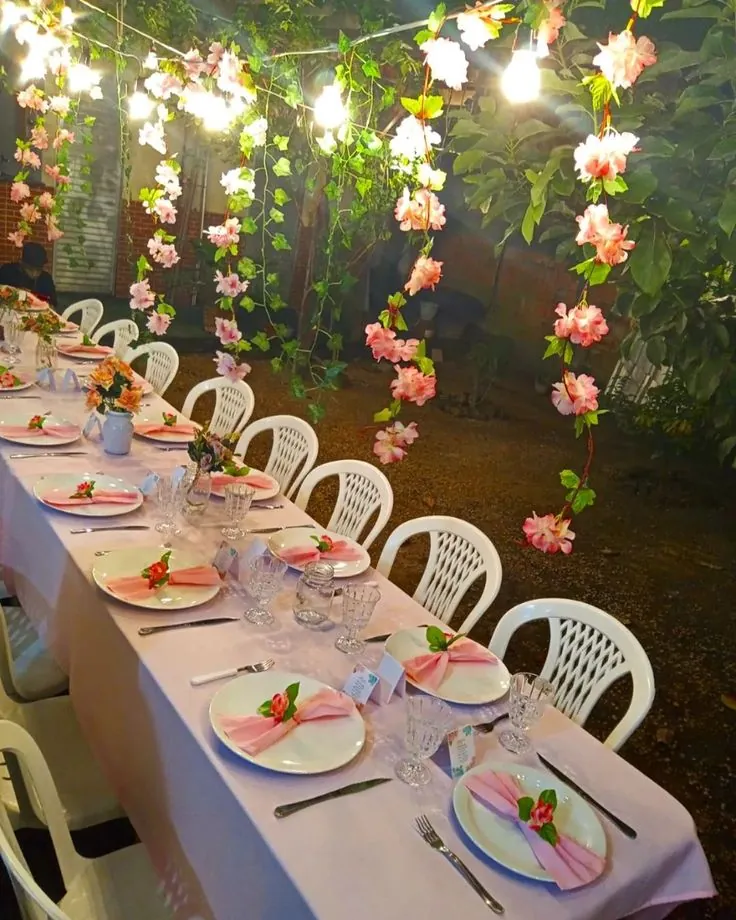 Mesa posta com flores e luzes para chá de mulheres